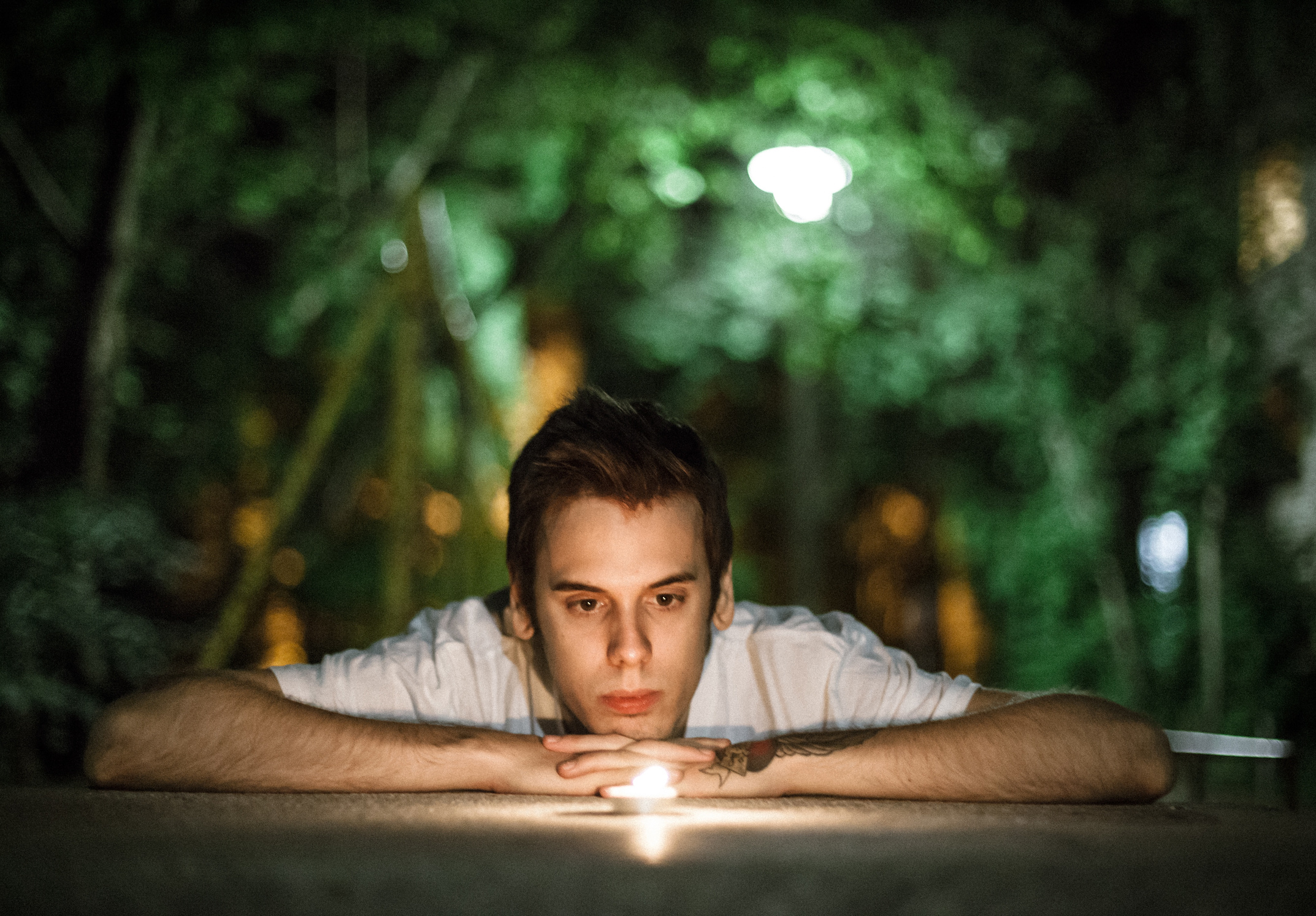 Man Looking at a Candle Outdoors